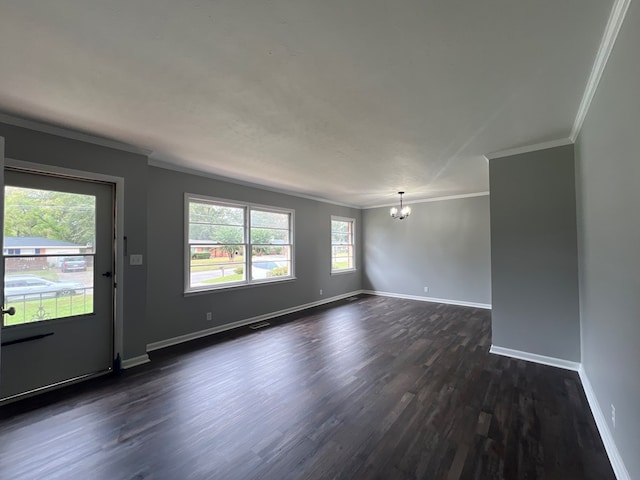 empty room with a notable chandelier, dark hardwood / wood-style floors, and crown molding