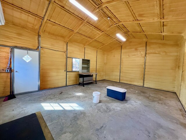 interior space with vaulted ceiling and concrete floors