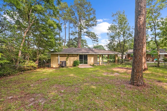 rear view of house featuring cooling unit, a yard, and fence