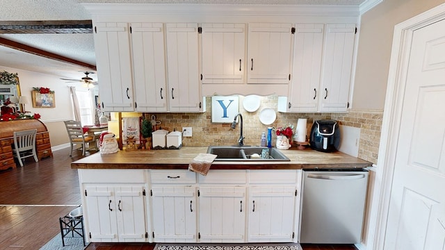 kitchen with sink, dishwasher, white cabinetry, dark hardwood / wood-style flooring, and decorative backsplash