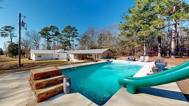 view of swimming pool with an outdoor structure and a patio area