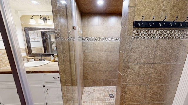 bathroom featuring vanity and tiled shower