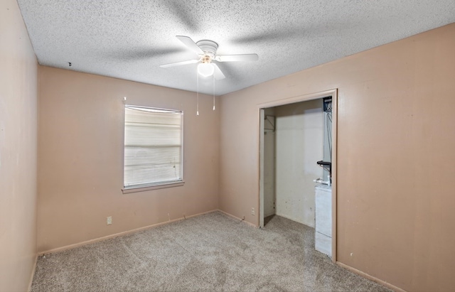 unfurnished bedroom featuring a closet, a textured ceiling, light colored carpet, and ceiling fan