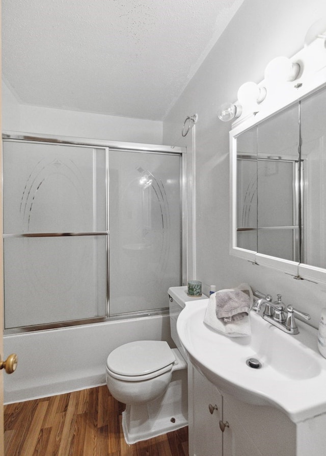 full bathroom featuring vanity, toilet, enclosed tub / shower combo, a textured ceiling, and wood-type flooring