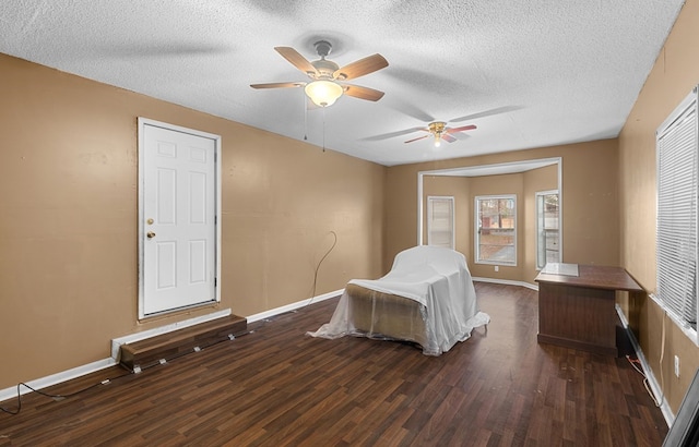 bedroom with ceiling fan, dark hardwood / wood-style floors, and a textured ceiling