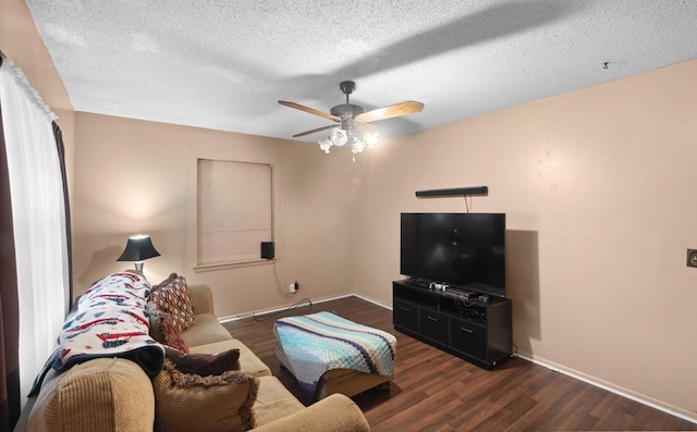 living room with ceiling fan, dark hardwood / wood-style flooring, and a textured ceiling