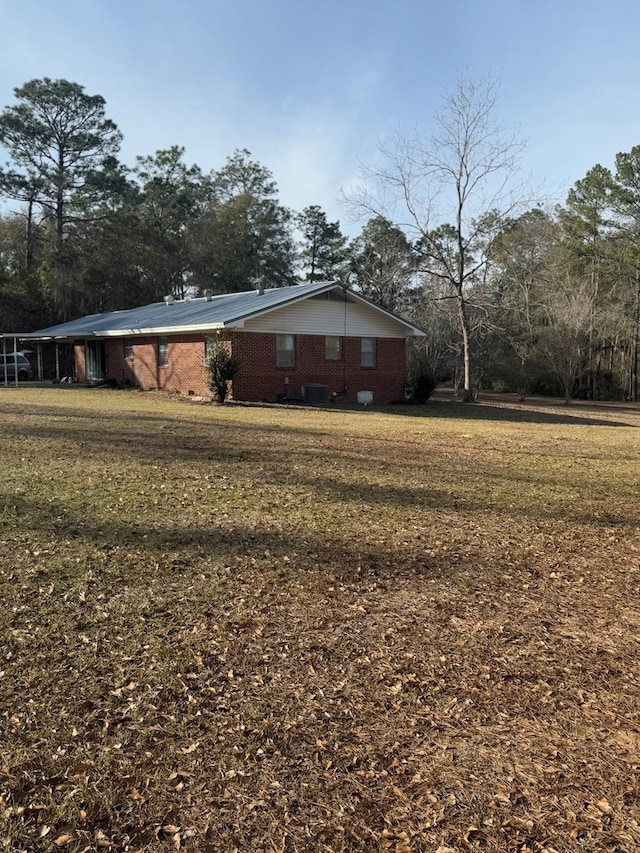 view of side of home featuring a yard and central air condition unit