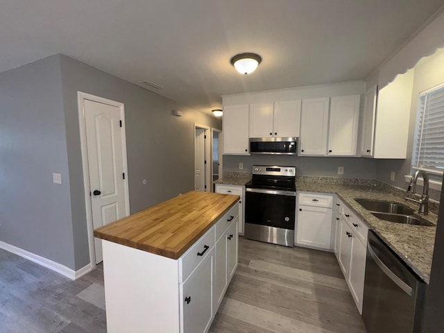 471 Faith St, Enterprise, AL 36330 - kitchen with stainless steel appliances, wooden counters, light wood-type flooring, and white cabinetry