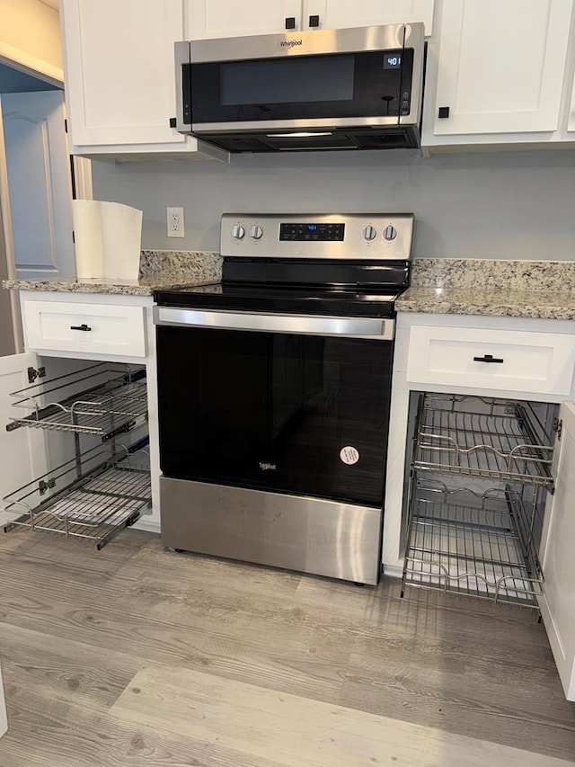 471 Faith St, Enterprise, AL 36330 - kitchen featuring appliances with stainless steel finishes, light wood-style flooring, white cabinetry, and light stone counters