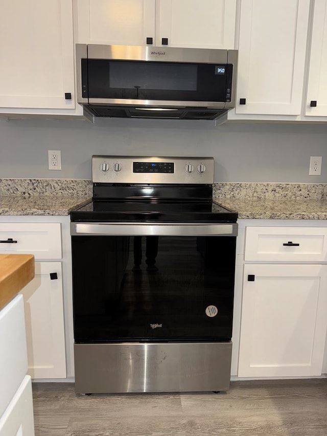 471 Faith St, Enterprise, AL 36330 - kitchen featuring stainless steel appliances, light wood finished floors, and white cabinets