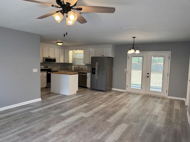 471 Faith St, Enterprise, AL 36330 - kitchen with stainless steel appliances, light wood-type flooring, ceiling fan, a chandelier, and white cabinets