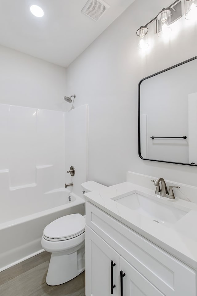 full bathroom with vanity, wood-type flooring, bathing tub / shower combination, and toilet