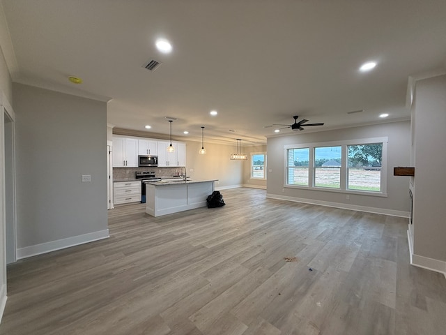 unfurnished living room featuring ceiling fan, light hardwood / wood-style floors, ornamental molding, and sink