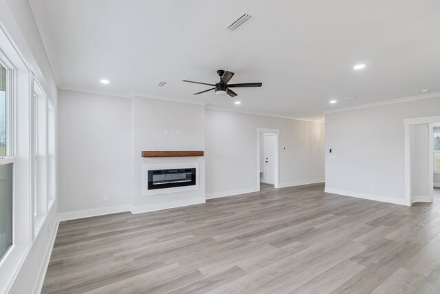 unfurnished living room featuring crown molding, light hardwood / wood-style floors, and ceiling fan