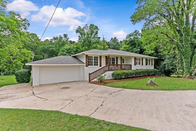 ranch-style home with a front yard, driveway, and covered porch