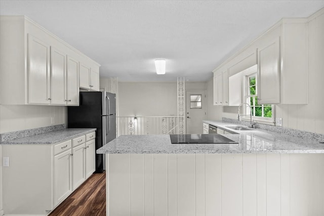 kitchen with a sink, white cabinetry, dark wood finished floors, and a peninsula