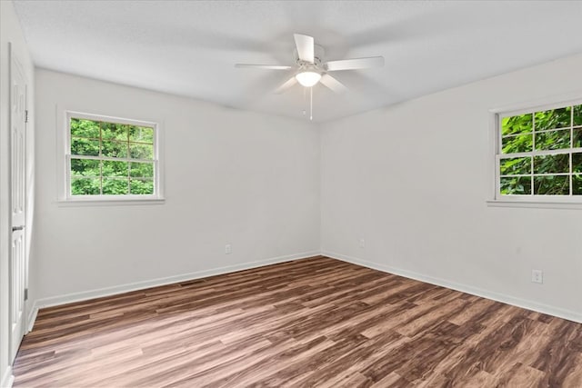 unfurnished room with wood finished floors, baseboards, and ceiling fan