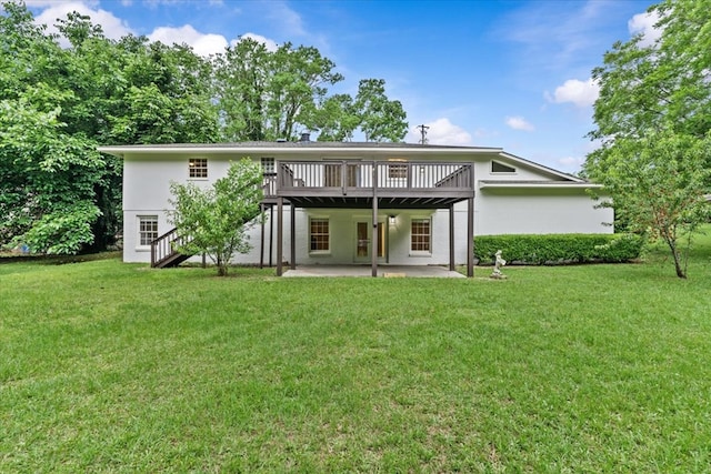 back of property with a deck, a patio, a lawn, stucco siding, and stairway