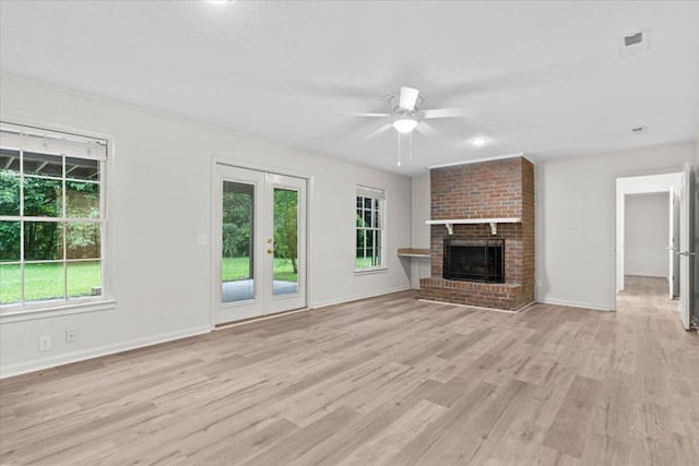 unfurnished living room featuring light wood-style flooring, a ceiling fan, a fireplace, and baseboards