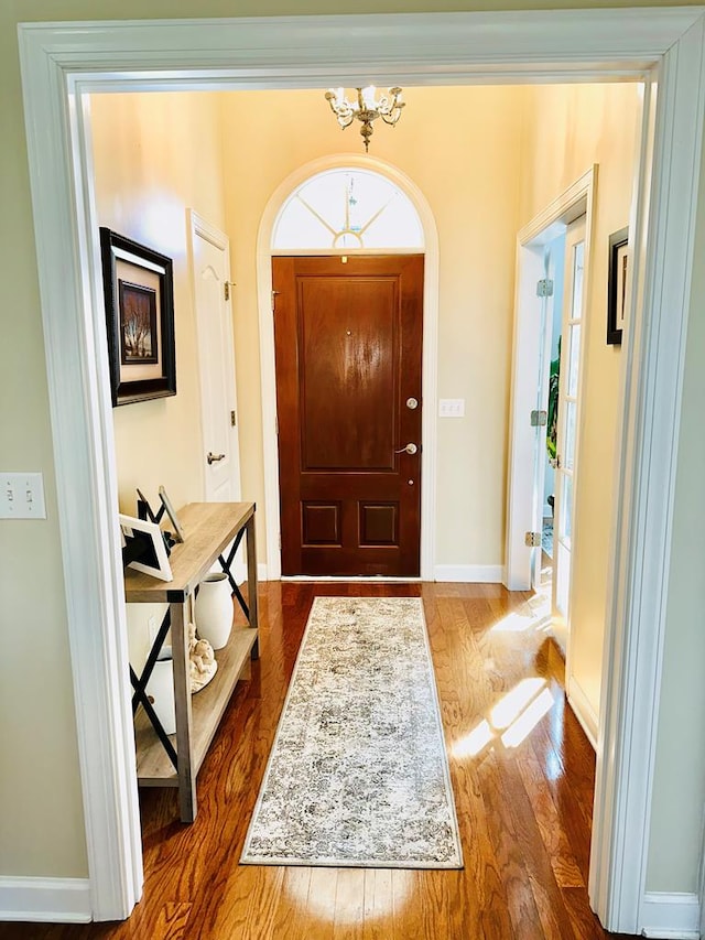 entrance foyer with hardwood / wood-style floors and a chandelier