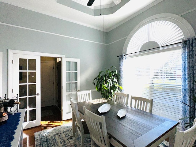 dining space with french doors, ornamental molding, a raised ceiling, ceiling fan, and hardwood / wood-style floors