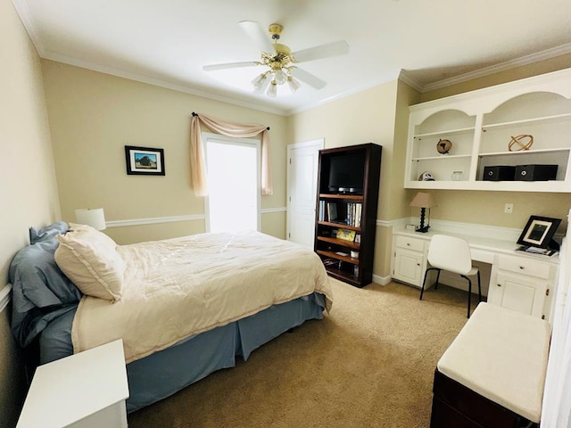 bedroom with ceiling fan, built in desk, light carpet, and ornamental molding