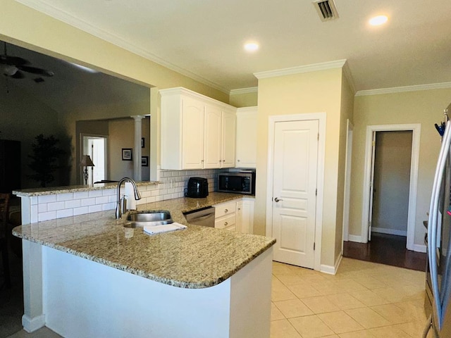 kitchen featuring kitchen peninsula, light stone counters, stainless steel appliances, sink, and white cabinets