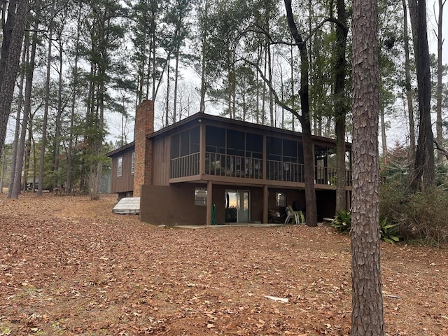 rear view of property featuring a sunroom