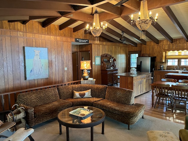 living room with sink, hardwood / wood-style flooring, vaulted ceiling with beams, a notable chandelier, and wood walls