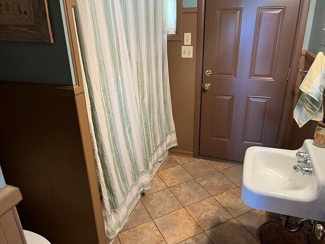 bathroom featuring walk in shower, sink, and tile patterned flooring