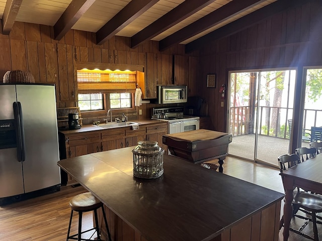 kitchen featuring sink, wood ceiling, stainless steel appliances, and vaulted ceiling with beams