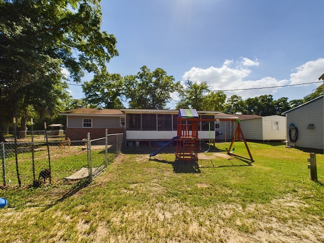 rear view of property with a playground and a yard