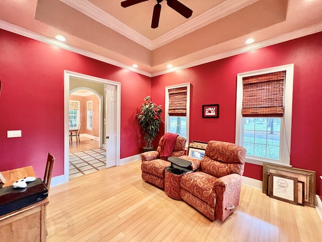 living area featuring ceiling fan, hardwood / wood-style floors, and ornamental molding