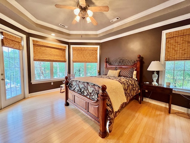 bedroom with multiple windows, ceiling fan, light hardwood / wood-style flooring, and ornamental molding