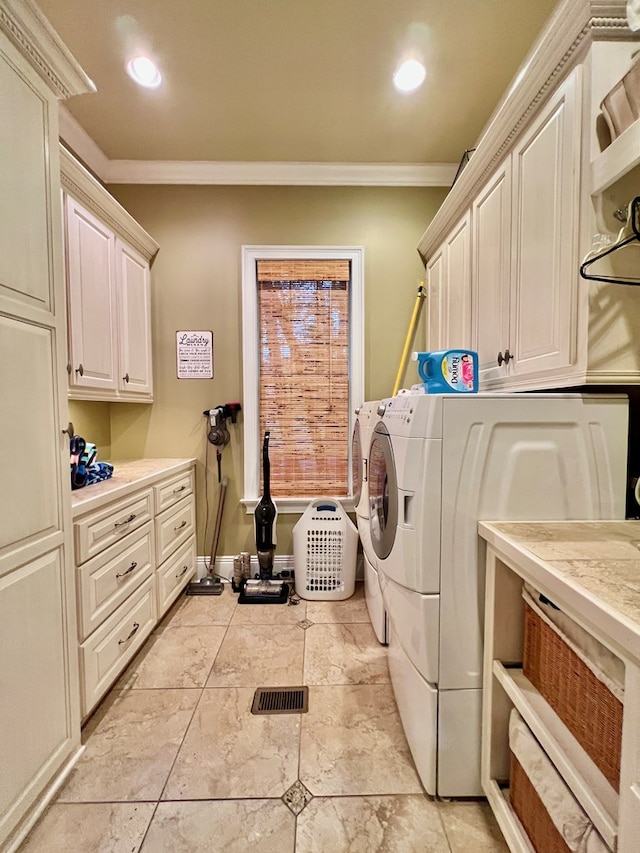 laundry room featuring cabinets, washer and dryer, and ornamental molding