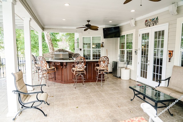 view of patio with a bar, french doors, area for grilling, and ceiling fan