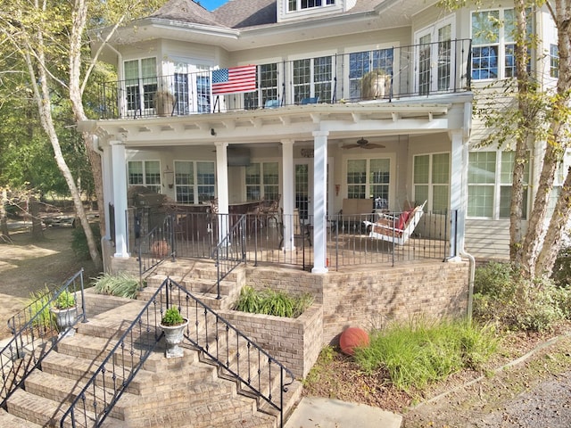 view of front of property with a patio area, ceiling fan, and a balcony