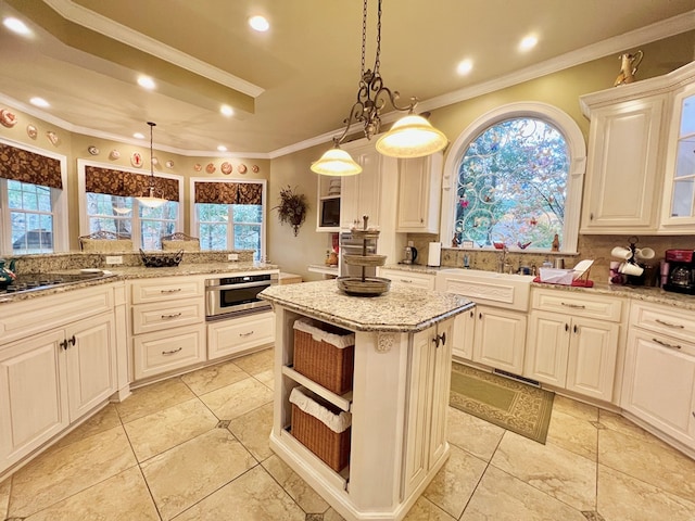 kitchen featuring light stone countertops, a wealth of natural light, a center island, and pendant lighting