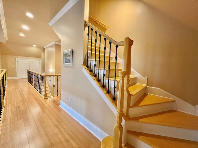 stairway with hardwood / wood-style flooring and crown molding