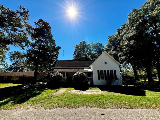 view of front of home featuring covered porch and a front yard