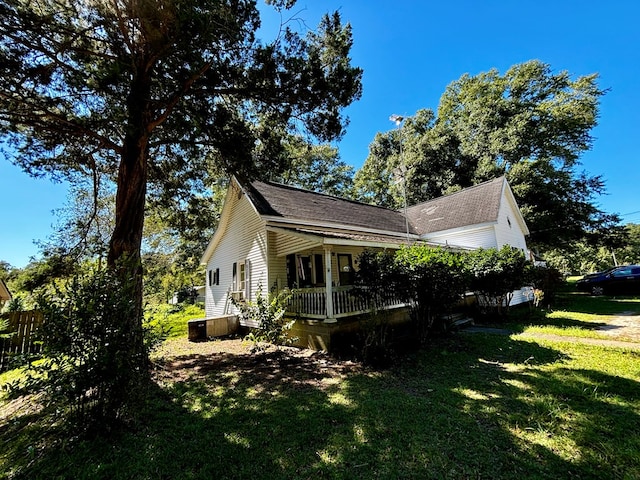 view of property exterior with a lawn and a porch