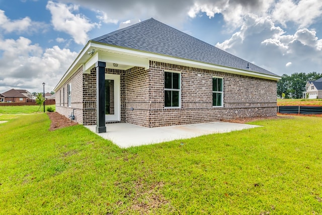 rear view of property featuring a lawn and a patio