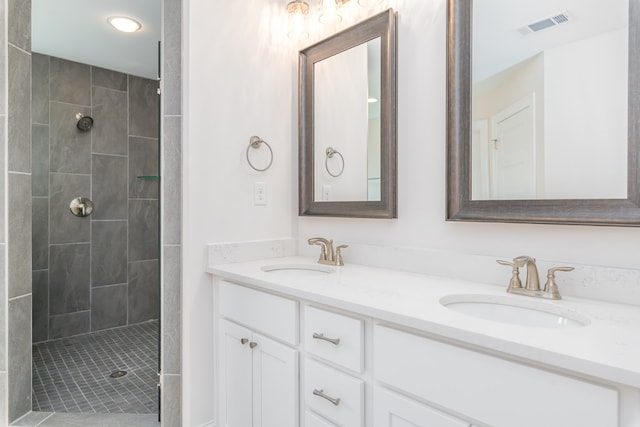 bathroom featuring a tile shower and vanity