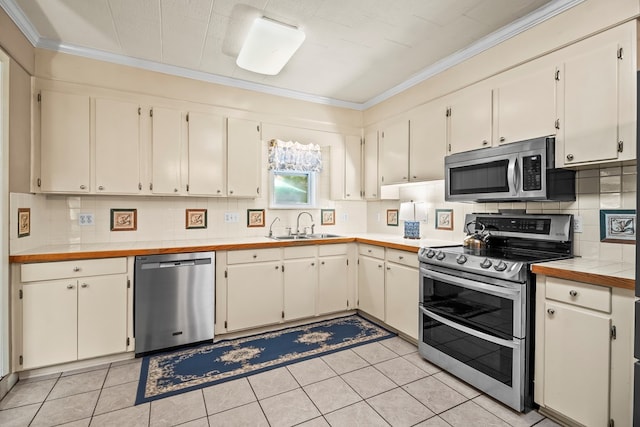 13215 E State Highway 52, Hartford, AL 36344 - kitchen featuring appliances with stainless steel finishes, crown molding, a sink, decorative backsplash, and light tile patterned floors