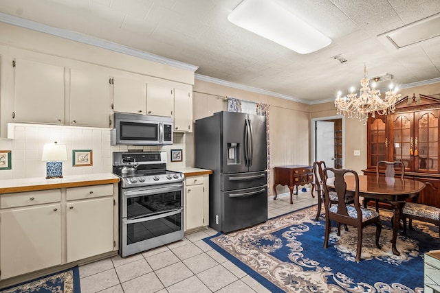 13215 E State Highway 52, Hartford, AL 36344 - kitchen featuring stainless steel appliances, light countertops, light tile patterned floors, a chandelier, and crown molding