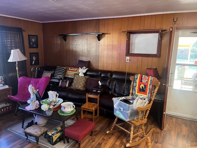 living room with wooden walls, crown molding, and hardwood / wood-style flooring