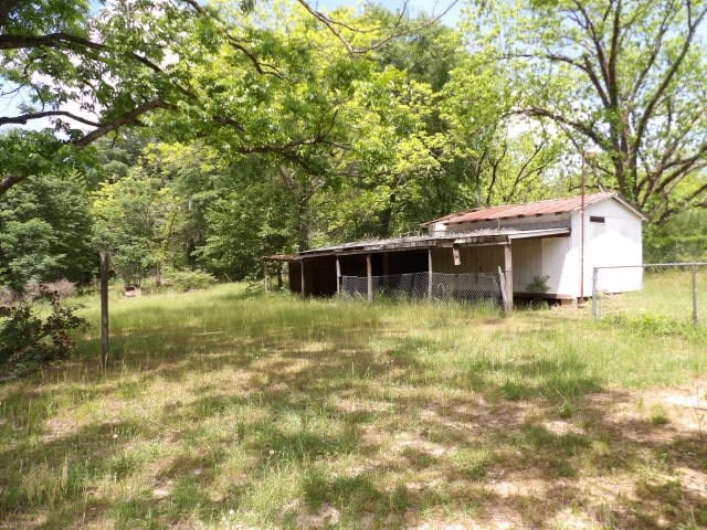 exterior space with fence and a view of trees