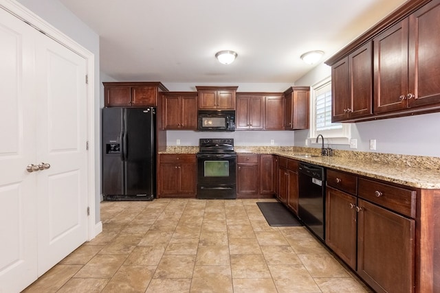 kitchen featuring a sink, light stone countertops, and black appliances