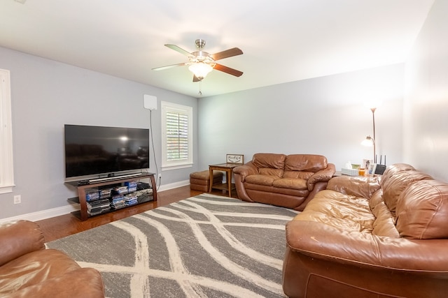 living area featuring ceiling fan and baseboards