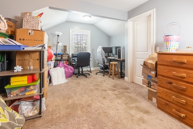 carpeted office space featuring baseboards and vaulted ceiling